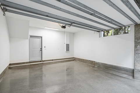 A large empty room with a concrete floor and white walls.