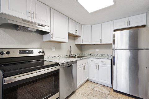 a kitchen with stainless steel appliances and white cabinets