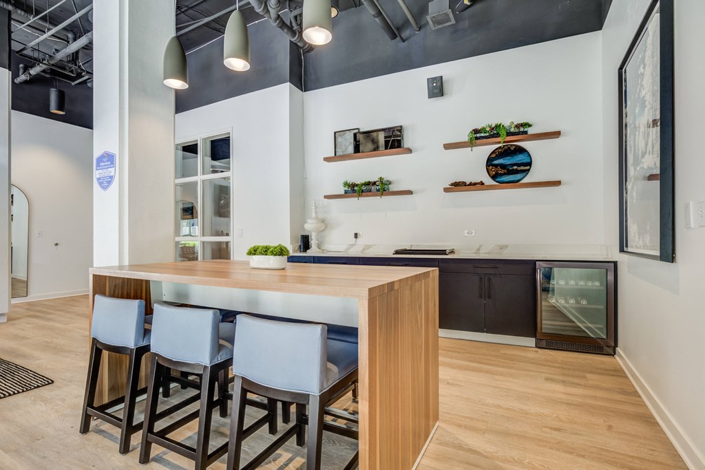 a kitchen with a wooden island with four stools in front of a kitchen counter