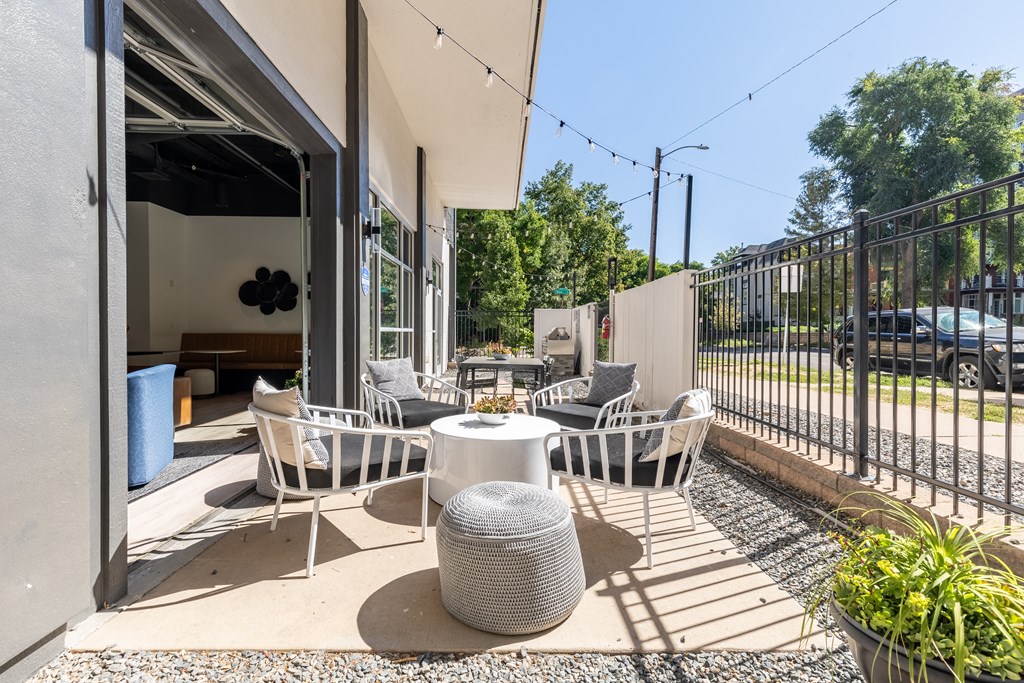 a patio with tables and chairs outside of a building