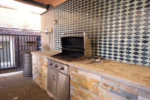 A tiled wall with a stone counter top and a built in oven.
