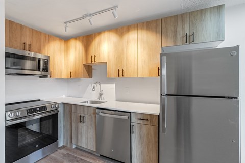 A modern kitchen with wooden cabinets and stainless steel appliances.