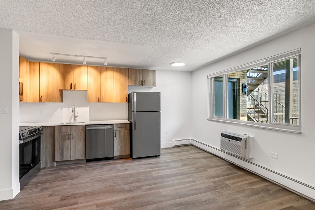 A kitchen with wooden cabinets and a stainless steel refrigerator.