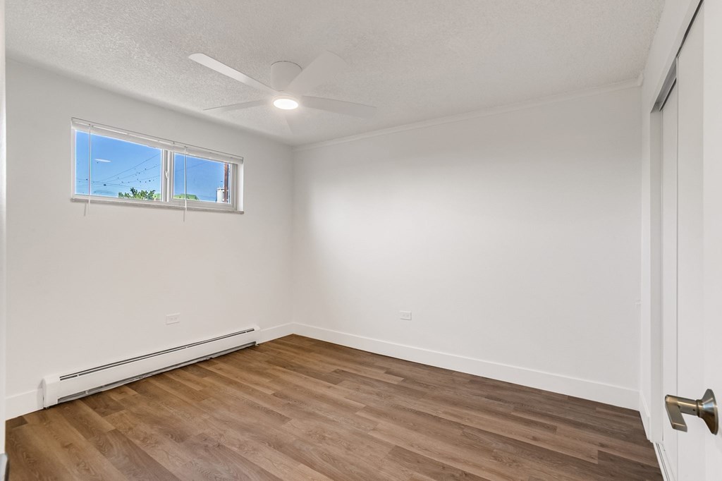 A room with a window and a ceiling fan.