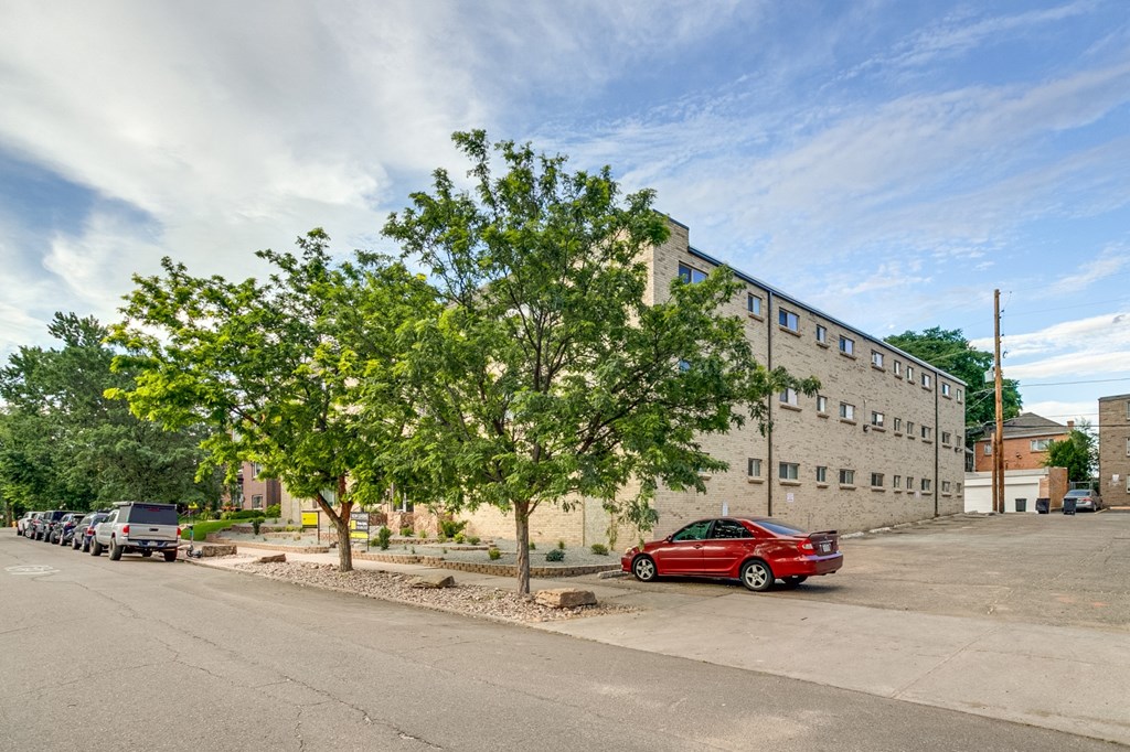 A red car is parked on the side of a street.