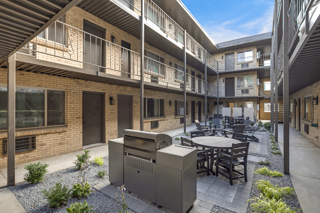 A courtyard with a table and chairs surrounded by buildings.