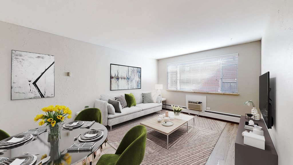 A living room with a couch, chairs, a coffee table, and a television.