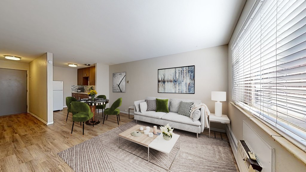 A living room with a white couch, green chairs, and a coffee table.