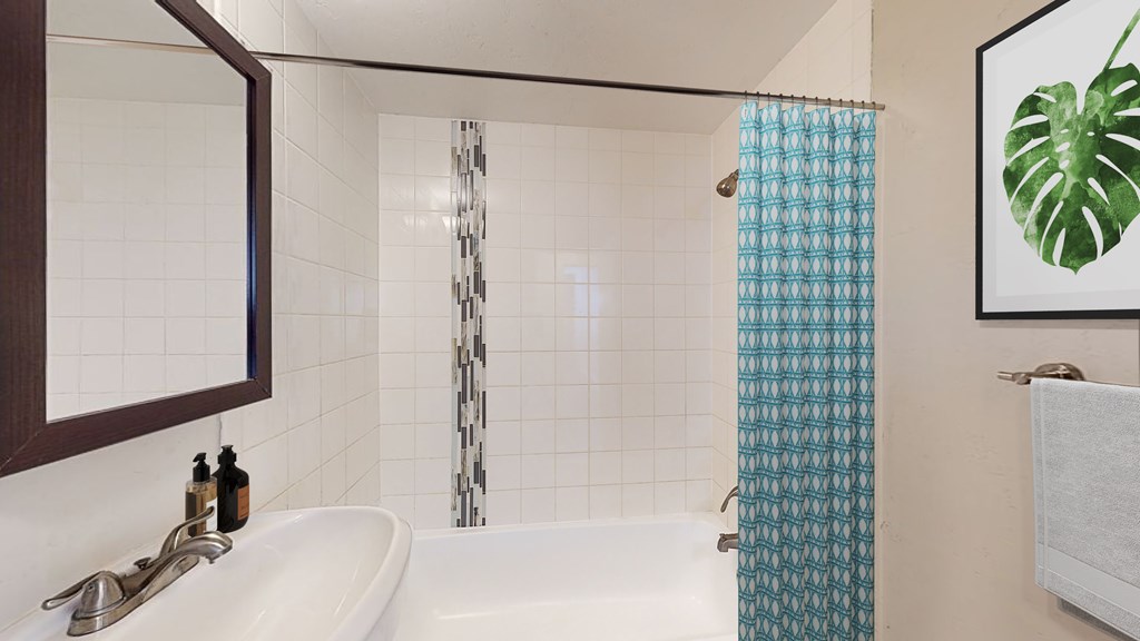 A bathroom with a white tub and a blue shower curtain.