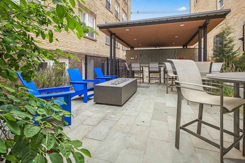 A patio with blue chairs and a table.