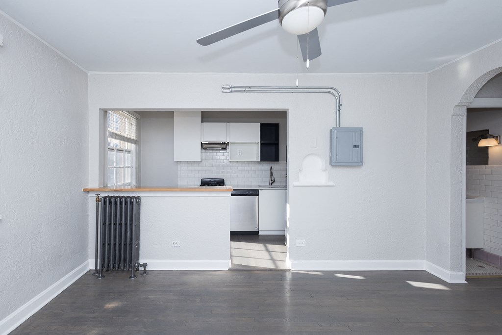 A room with a ceiling fan and a radiator on the floor.