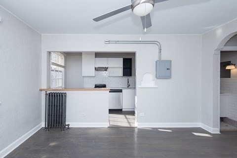 A room with a ceiling fan and a radiator on the floor.