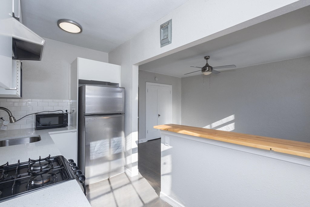 A modern kitchen with a stove top oven and a refrigerator.
