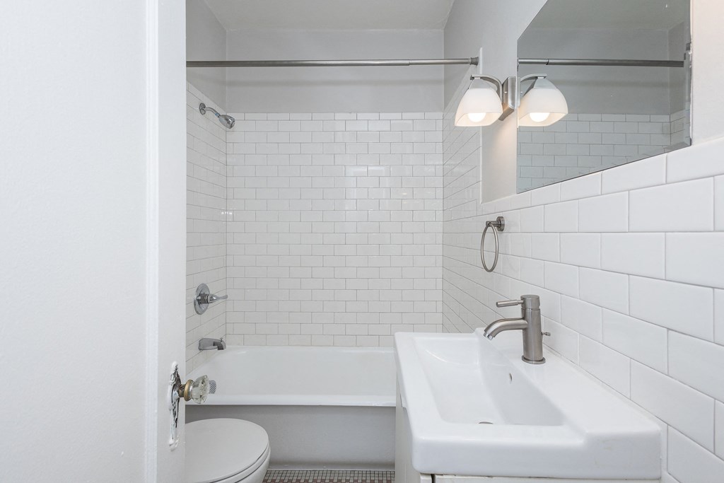 A white bathroom with a toilet, sink, and bathtub.