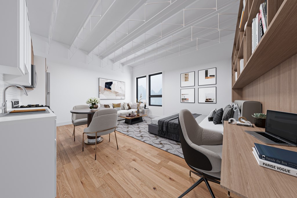 A modern living room with a grey sofa and a wooden floor.