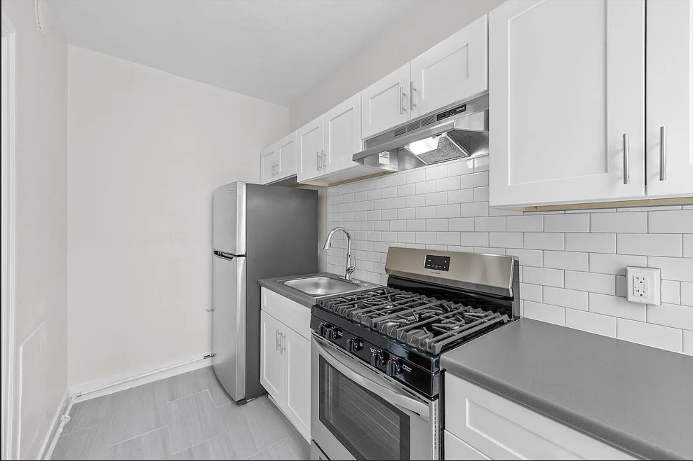 a kitchen with stainless steel appliances and white cabinets