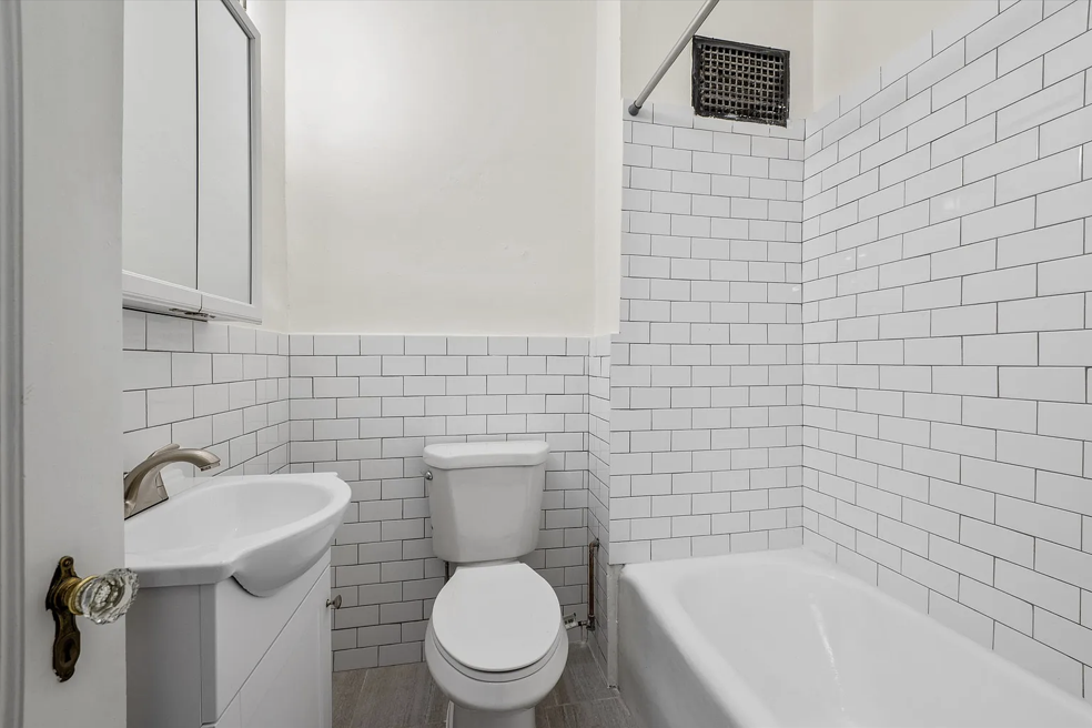 a white bathroom with a toilet and a sink