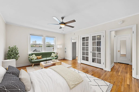 a bedroom with a couch and a ceiling fan