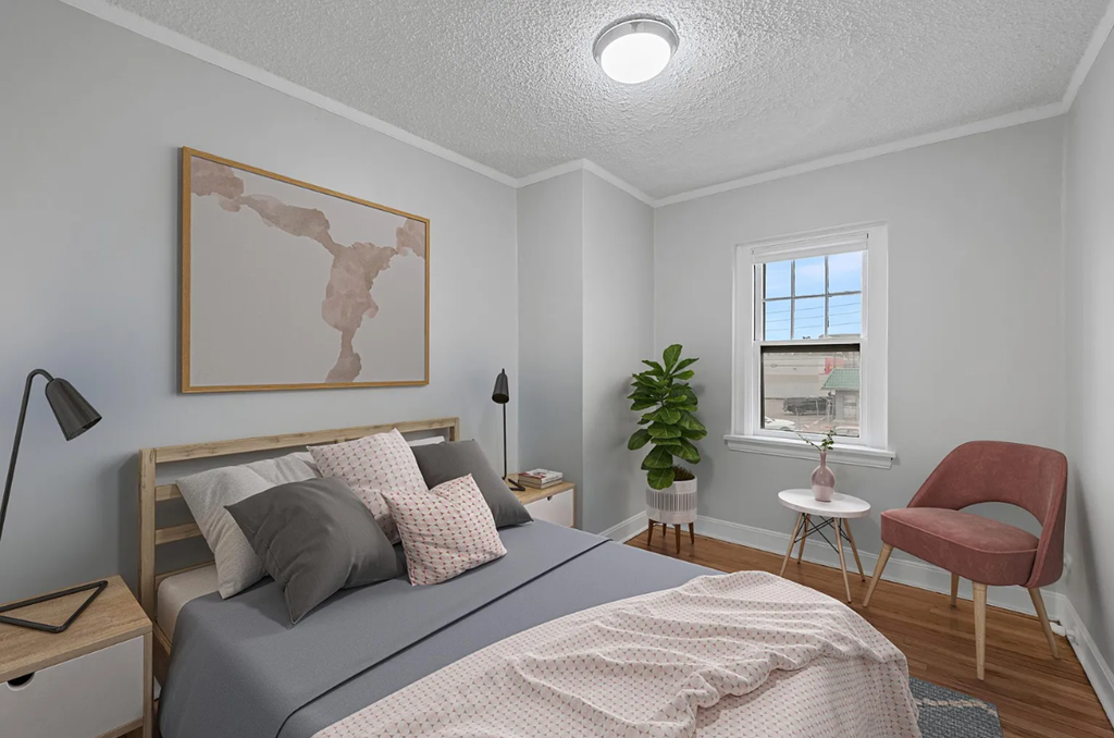 a bedroom with a bed and a chair and a window