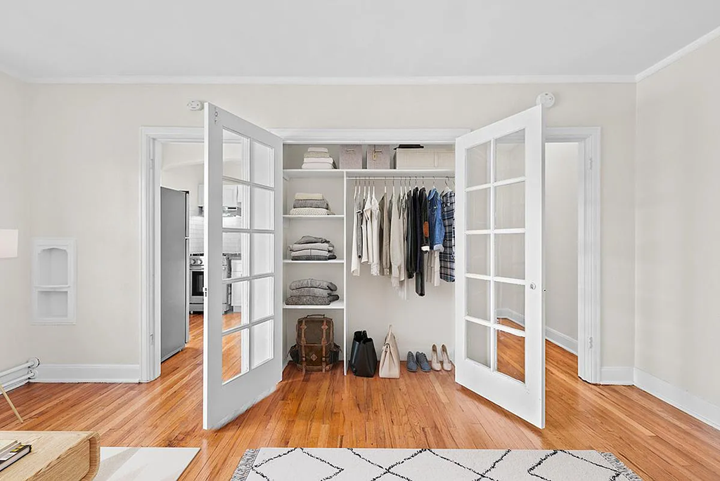 a living room with a white closet with sliding doors