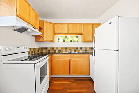 a kitchen with white appliances and wooden cabinets