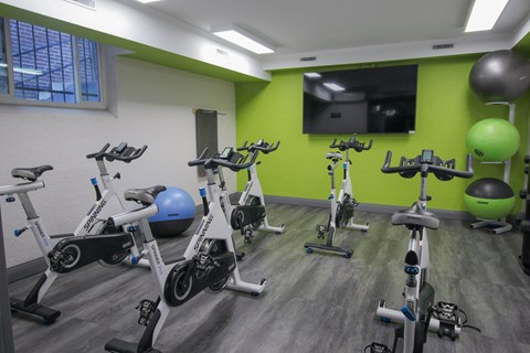 A gym with a green wall and exercise equipment.
