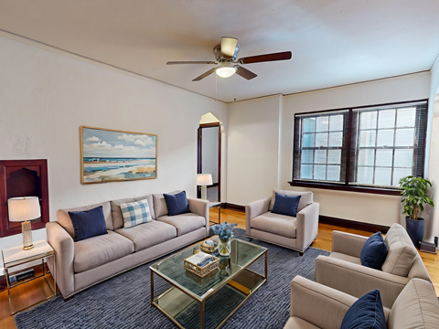 A living room with a sofa set, a coffee table, and a painting on the wall.