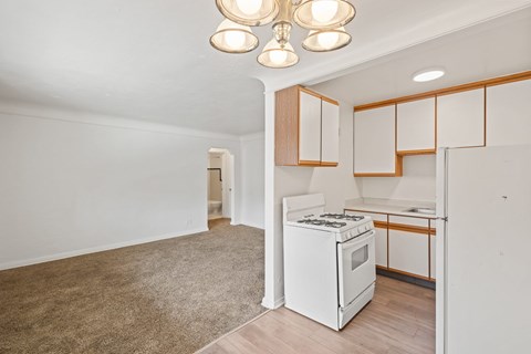 A kitchen with white appliances and wooden cabinets.
