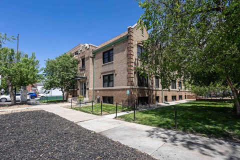 A large brick building with a tree in front of it.