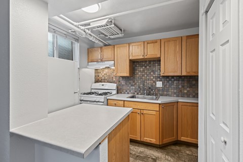 A kitchen with wooden cabinets and a white countertop.