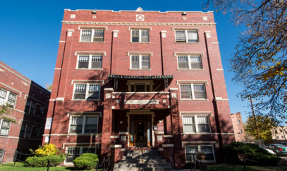 A red brick building with a balcony on the second floor.