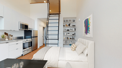A modern kitchen with a staircase leading to the upper floor.