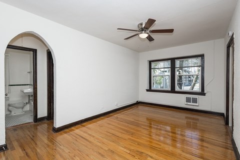 A room with a ceiling fan and a window.