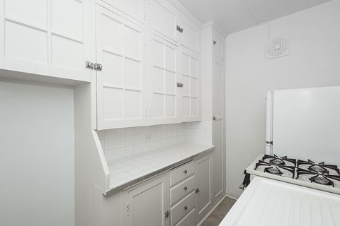 A white kitchen with a stove top oven.