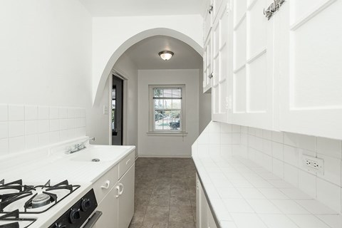 A white kitchen with a black stove top.