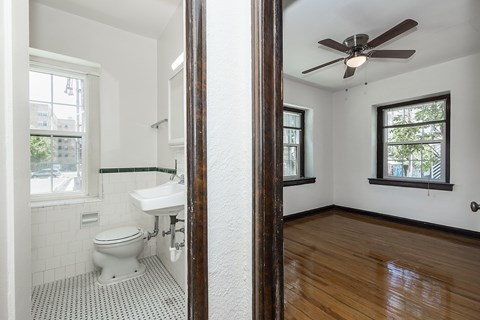 A bathroom with a toilet, sink, and a window.