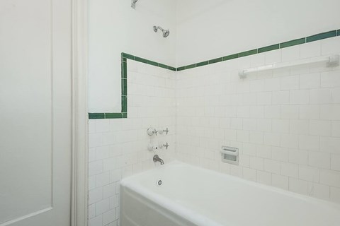 A white bathroom with a green border on the wall.