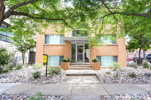 A modern house with a brick facade and a front yard with gravel and plants.
