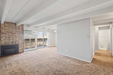 A living room with a fireplace and a carpet.