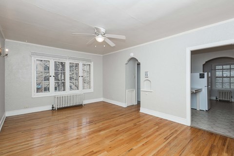 A room with a ceiling fan and a window with a view of a snowy landscape.