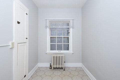A white room with a window and a radiator.