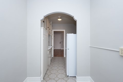 A white doorway leads to a hallway with a tiled floor.