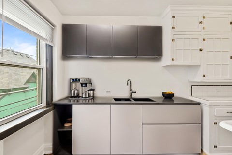 A kitchen with a black countertop and white cabinets.