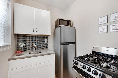 a kitchen with a stove refrigerator and sink