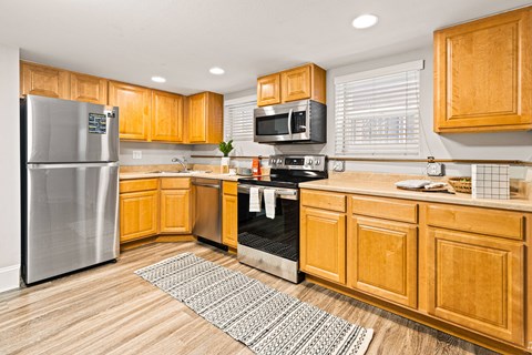 a kitchen with wooden cabinets and stainless steel appliances