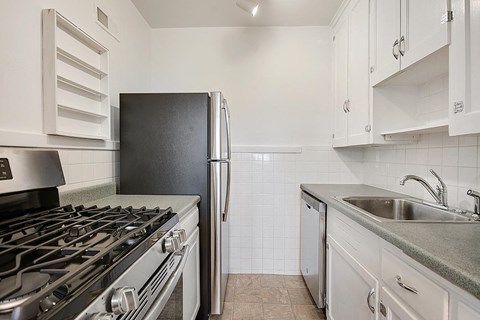 a kitchen with a stove refrigerator and sink