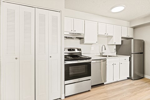 a kitchen with white cabinets and stainless steel appliances