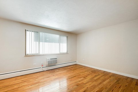A room with a window and a fan on the floor.