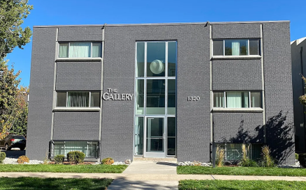 The Gallery building is grey and has a glass door.