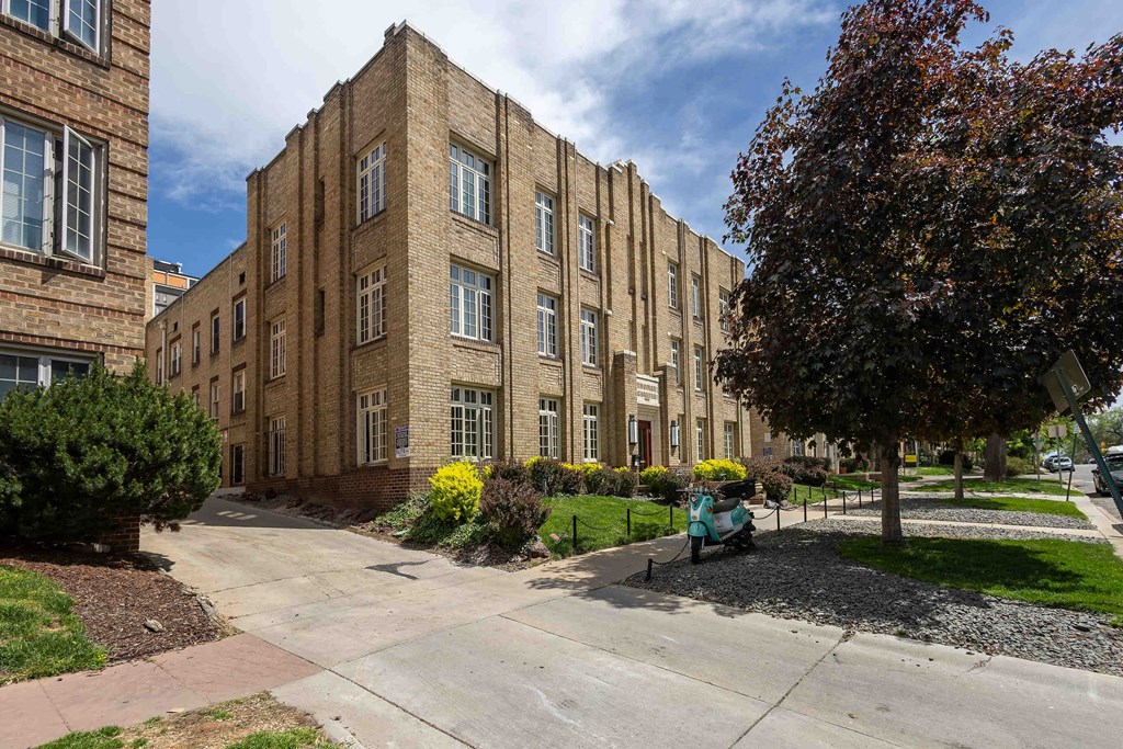 A large brick building with a tree in front of it.